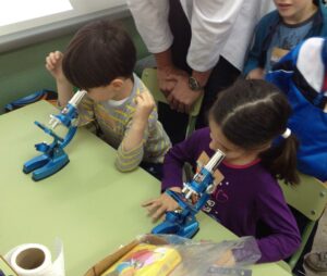 Dos alumnos ensayan con microscopios infantiles.