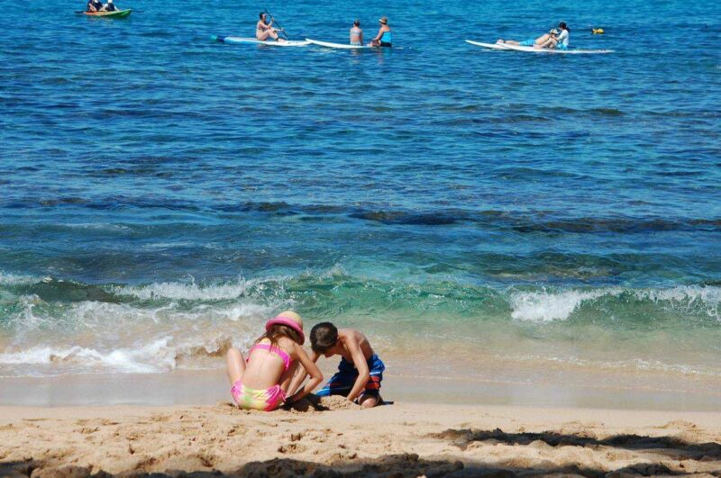 Imagen de dos niños jugando en la orilla de una playa. / Pixabay